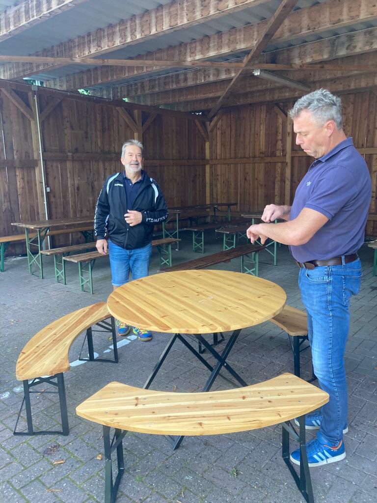 Dieter und Jörn stellen die Tische und Stühle auf.