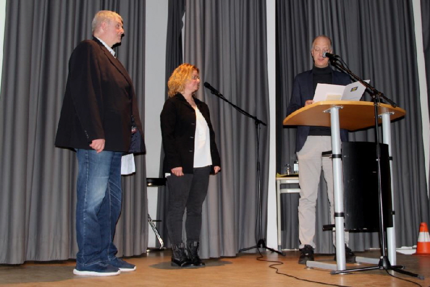 Der Bürgermeister Tim Willy Weber übergibt eine Urkunde der Gemeinde.